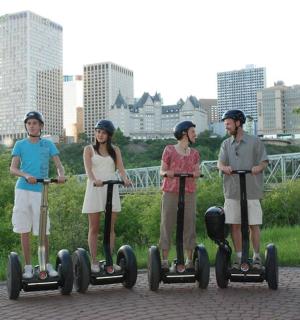 skupina čtyř lidí jedoucích na koloběžkách