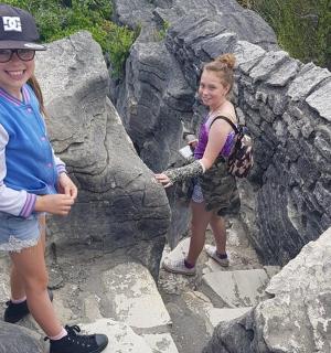 两个人站在岩壁上的岩石上