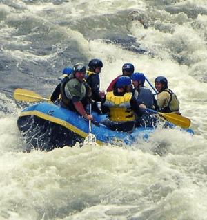 一群人坐在河里的木筏上