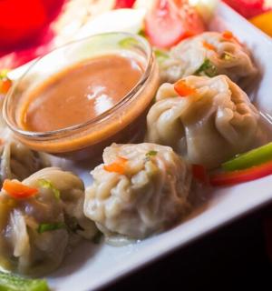 一盘有饺子和蘸酱的食物