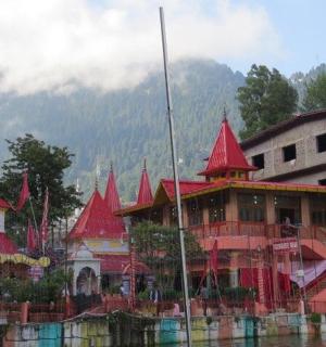 a building with red roofs on the water next to a building