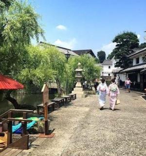 two women walking down a street next to a river