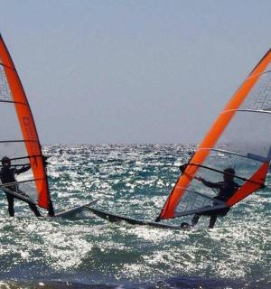 zwei Personen sind Windsurfen im Meer