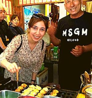 一位女士站在餐桌前，桌上摆着食物