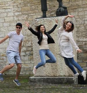 三个人在雕像前跳跃