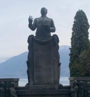 a statue of a man standing next to the water