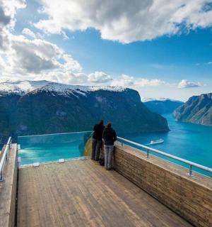 两个人站在木板路上俯瞰一片水域