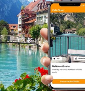 a person holding up a cell phone in front of a river