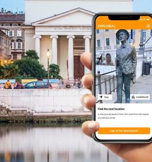 osoba držící mobilní telefon, aby vyfotila sochu