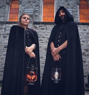 a man and woman dressed in black standing in front of a building