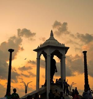 a group of people standing in front of a sunset