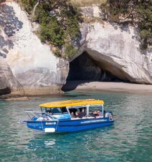 洞穴附近水中的一艘蓝黄色小船