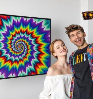 一名男子和一名女子正在拍摄一幅画