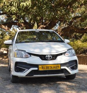 a white car parked in front of a tree