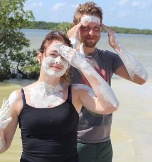 海滩上，一男一女脸上都涂着防晒霜