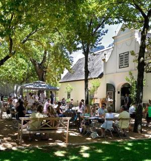 一群人坐在建筑物前的桌子旁