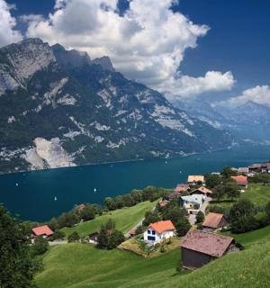 a small village on a hill next to a lake