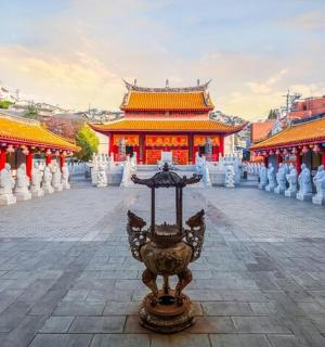 a temple in an asian city with a lamp in front