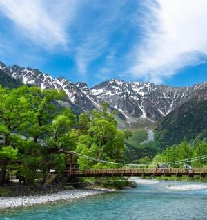 一座横跨河流的桥，背景是群山