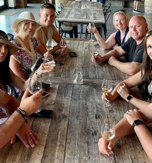 一群人围坐在桌旁,手捧酒杯