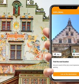 a person holding up a cell phone in front of a building