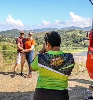 一名男子正在拍摄两名站在车辆旁边的男子