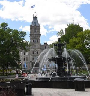 a fountain in front of a building with a clock tower