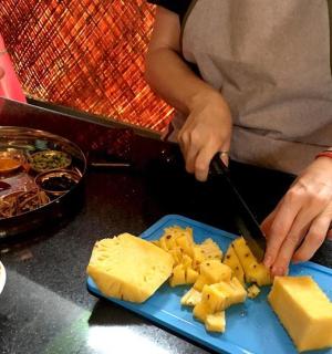 a person cutting cheese on a blue plate