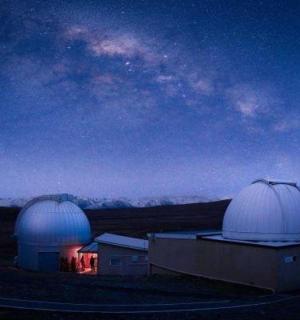 two observatories sitting on top of a field at night