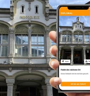 una persona sosteniendo un teléfono celular frente a un edificio