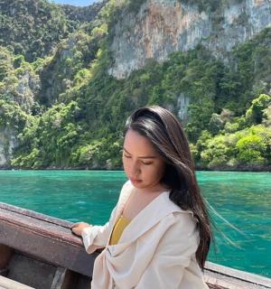 一名女子坐在水边的桥上