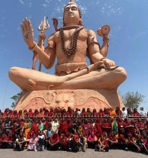 a group of people standing in front of a large statue
