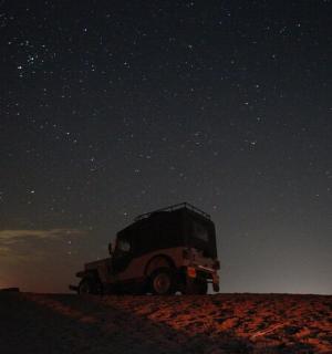 一辆卡车停在星空下的沙滩上