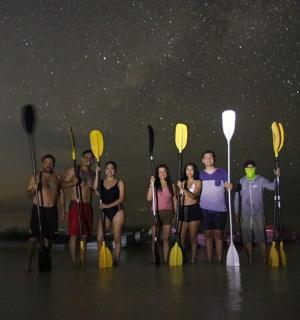 一群人站在水中，手里拿着桨