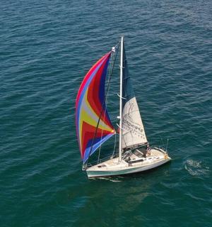 a boat with a colorful sail in the water