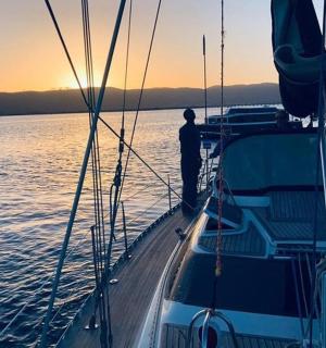 a man standing on the front of a boat in the water