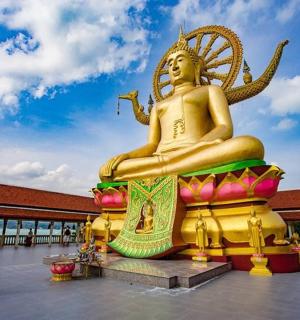 a woman standing in front of a large golden statue