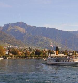 ein Boot auf dem Wasser mit Bergen im Hintergrund