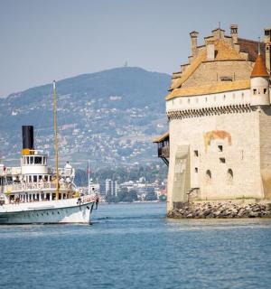 loď ve vodě vedle hradu