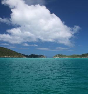一大片水域,群山环绕,天空多云