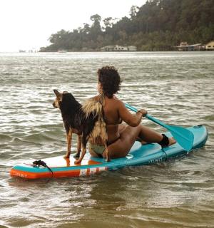 a man and a dog on a paddle board in the water