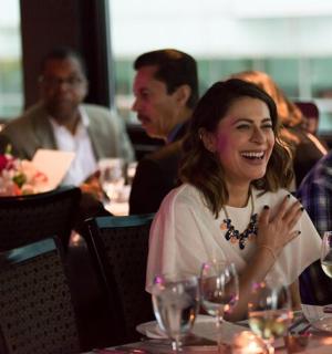 กลุ่มคนกำลังนั่งอยู่ที่โต๊ะพร้อมแก้วไวน์