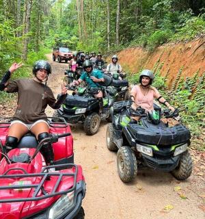 a group of people riding atvs on a dirt road