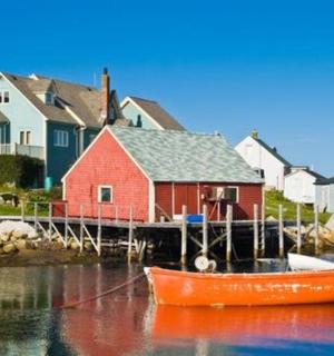 a boat is docked in front of a red house