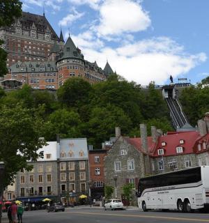 ein weißer Bus, der eine Stadtstraße mit Gebäuden entlangfährt