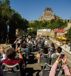a crowd of people sitting in chairs with their hands up