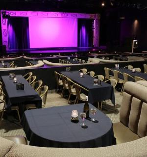 一间有桌椅和紫色屏幕的房间