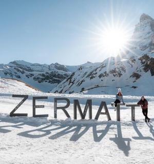 due persone sugli sci sulla neve con la scritta Zermatt