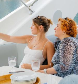 两名女子坐在船上的桌子旁