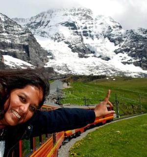 一名妇女指着一座白雪覆盖的山峰